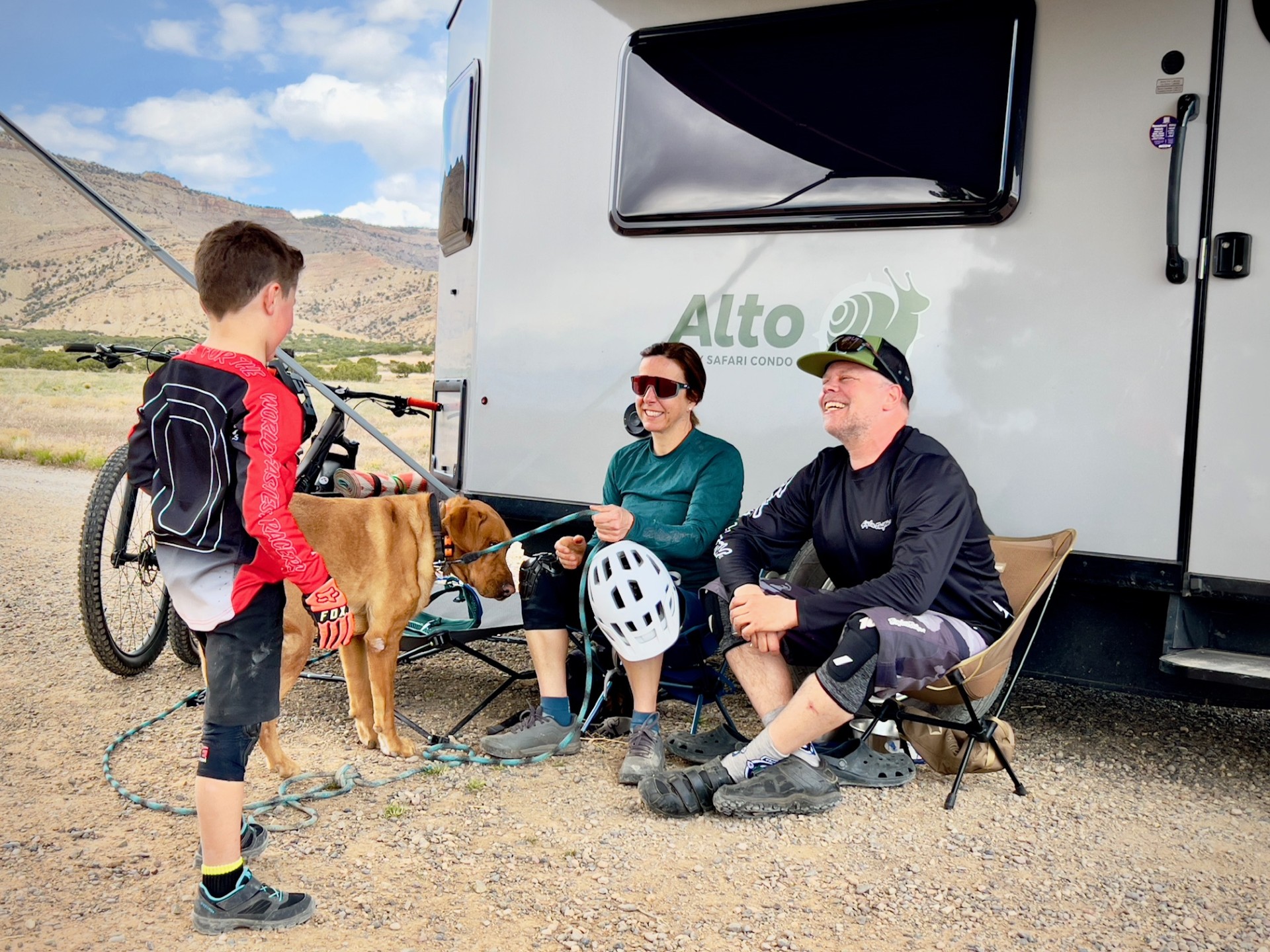 Famille détendue après une sortie vélo de montagne — logo Alto Safari Condo visible