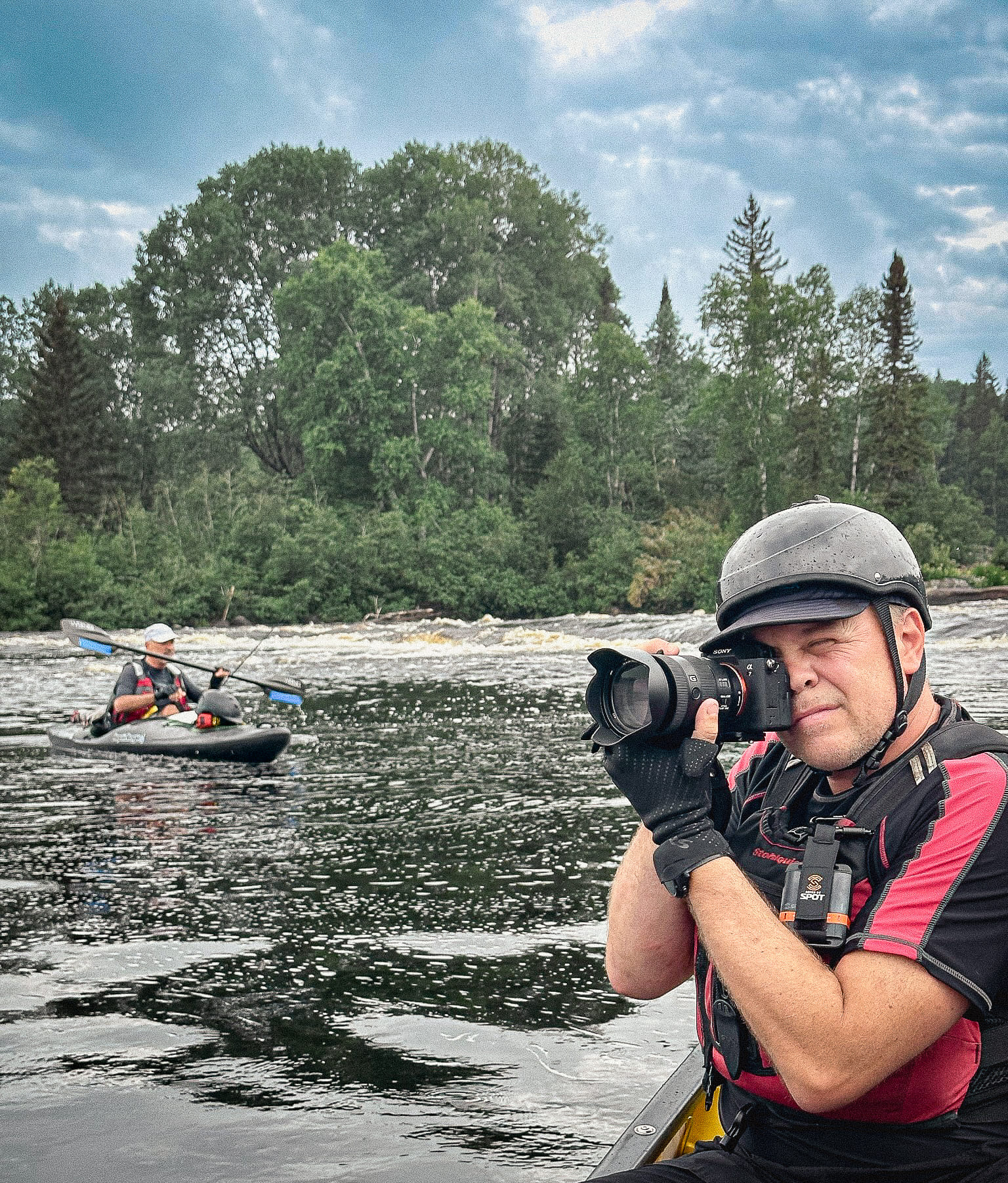 Stéphane Boulay en action sur la rivière, appareil Sony à la main, casque, gilet de sauvetage