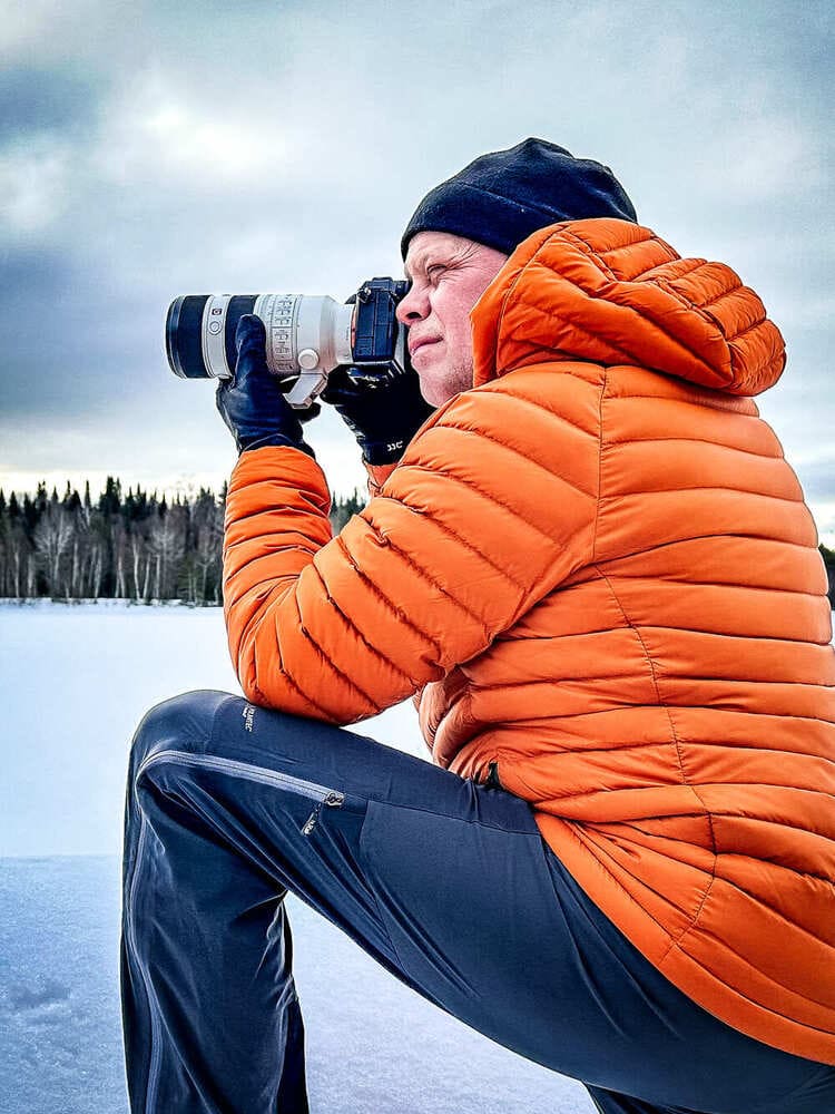 Stéphane Boulay, photographe plein air, manteau orange, téléobjectif, en action sur le terrain